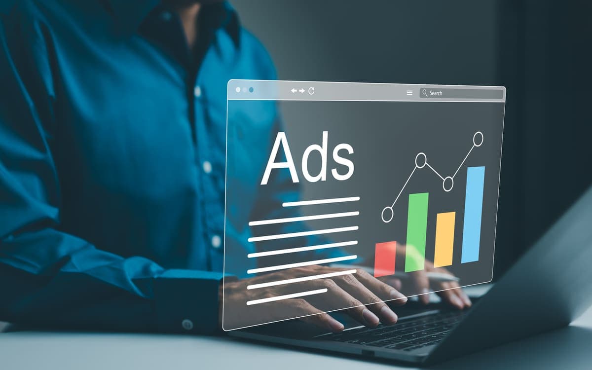 Analyst tracking paid ad performance and rising campaign metrics on a laptop